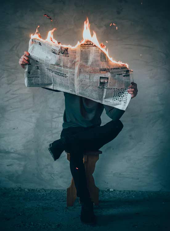 a man is reading burning newspaper